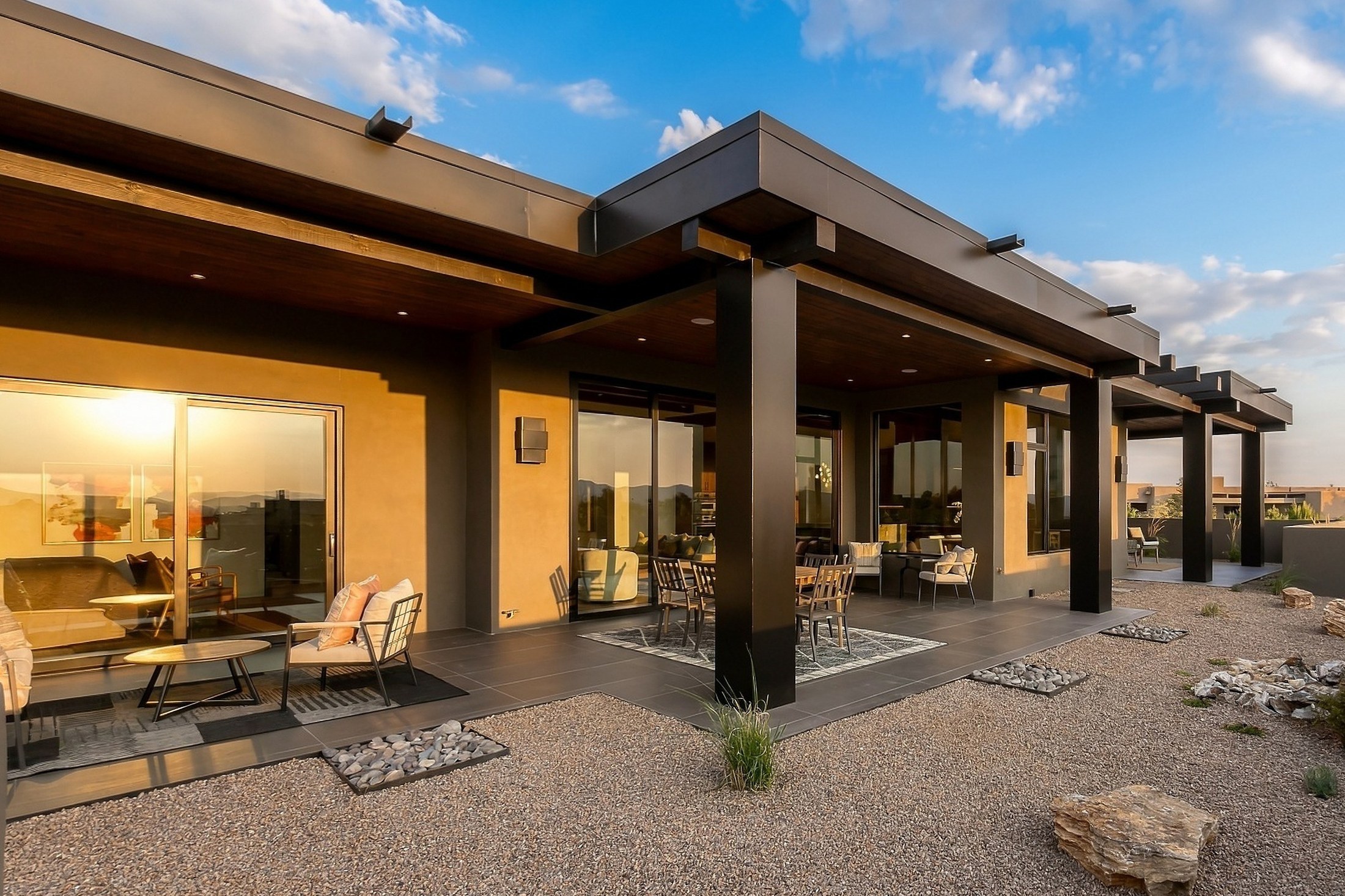 Pampa by Clemens Builders from the backyard at golden hour, the long portal and steel columns under a big sky